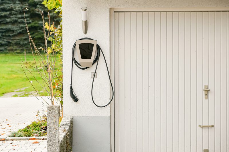 Level 2 EV charger installed on the exterior wall of a residential garage