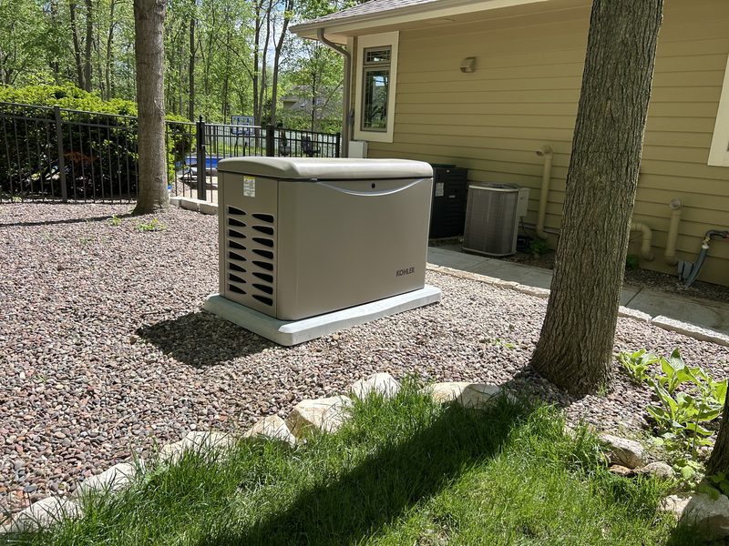 Kohler standby generator installed on a concrete pad beside a home
